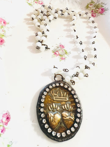 Necklace with a heart and crown pendant on a floral background