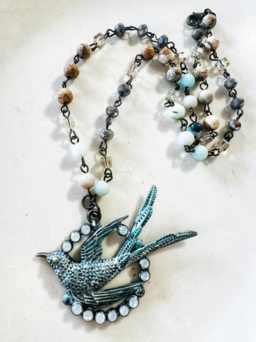 Necklace with a bird pendant on a light background