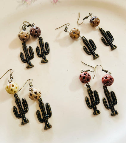 Cactus-shaped earrings on a light background