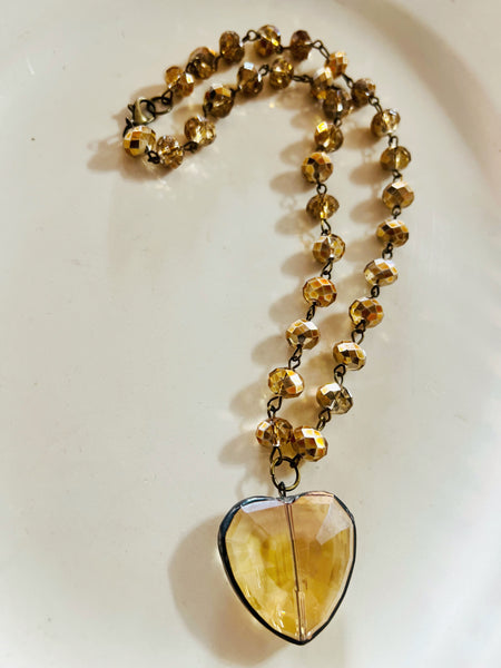 Necklace with a heart-shaped amber pendant on a white background