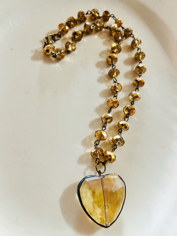 Necklace with a heart-shaped amber pendant on a white background