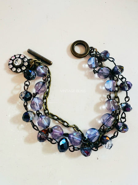 Purple beaded bracelet with a clasp on a white background