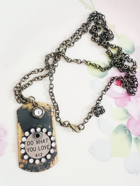 Necklace with a dog tag that says 'Do What You Love' on a floral background