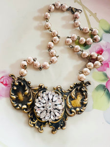 Necklace with decorative clasp and pearl chain on a floral background