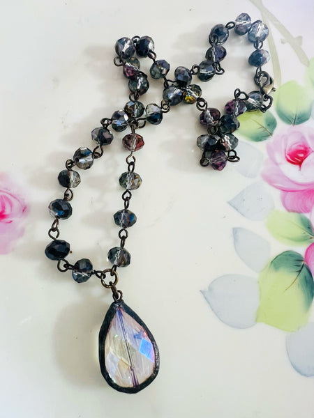 Necklace with a teardrop-shaped pendant on a floral background