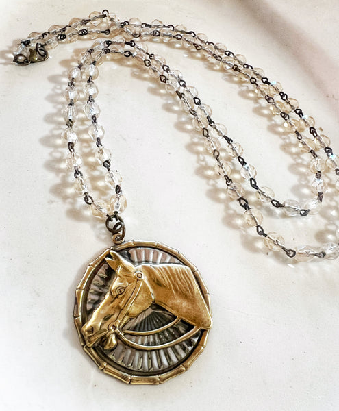 Necklace with a gold horse pendant on a white background