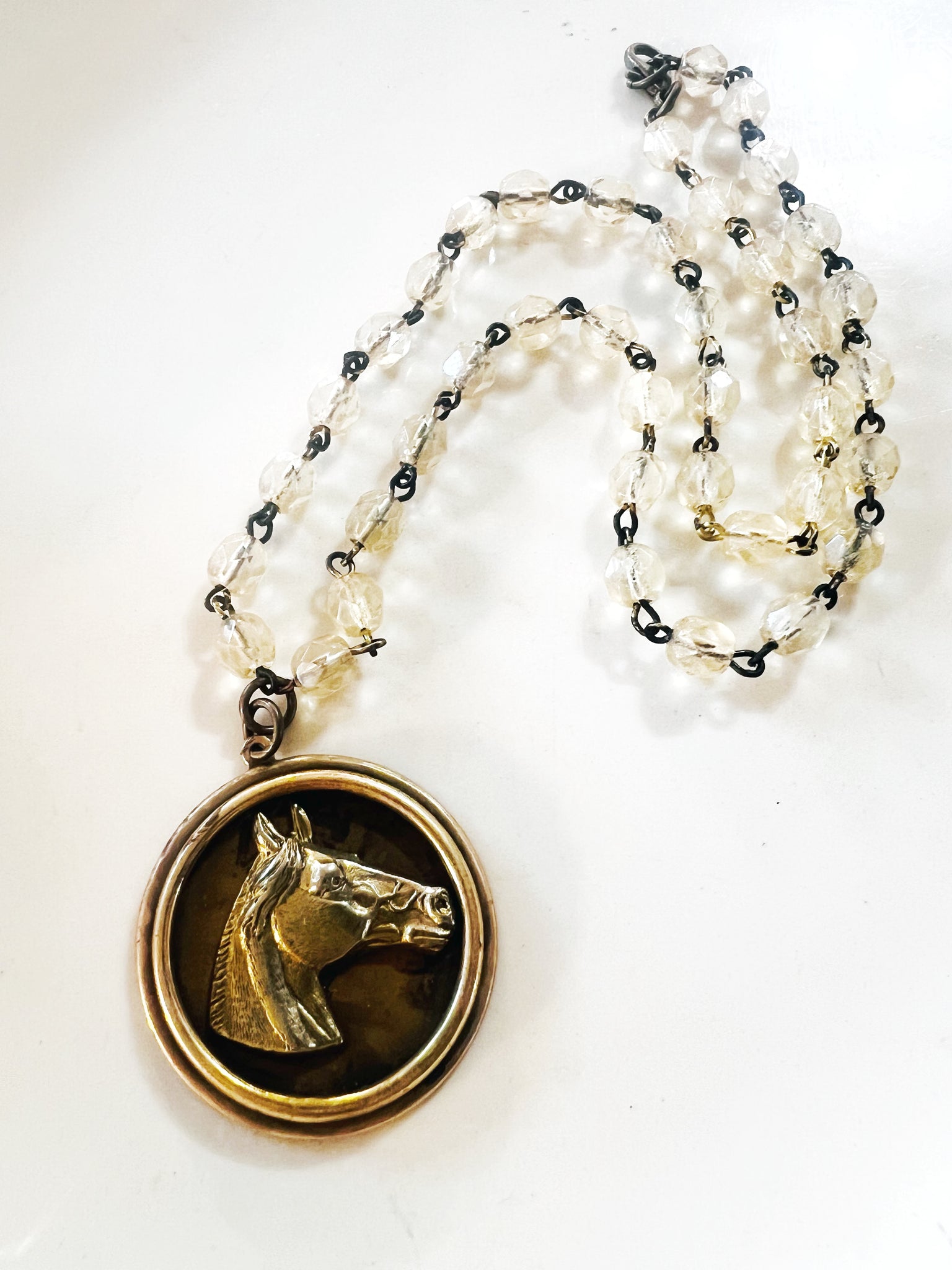 Necklace with a pendant featuring a horse's head on a white background