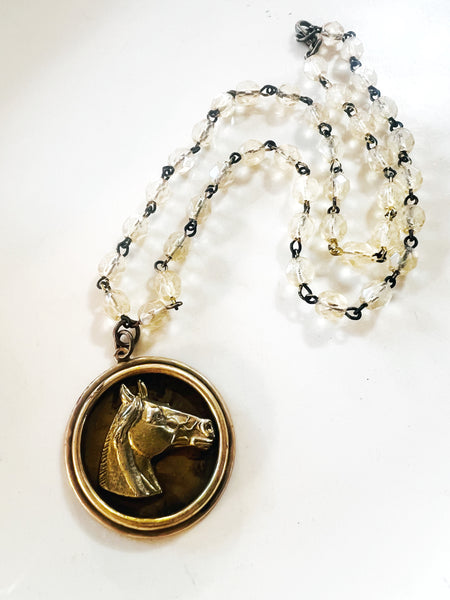 Necklace with a pendant featuring a horse's head on a white background