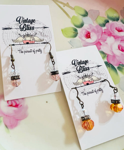 Pair of earrings on 'Vintage Bliss' branded cards with floral background
