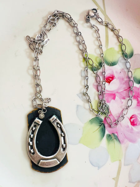 Silver necklace with a black pendant on a floral background