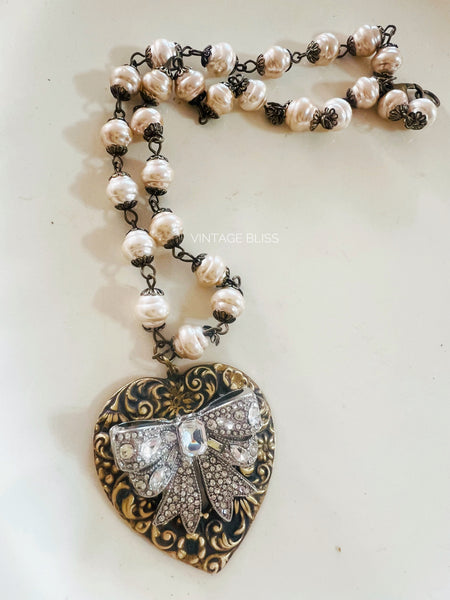 Necklace with heart-shaped pendant and pearl chain on a white background