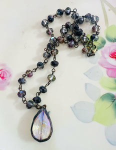 Necklace with a teardrop-shaped pendant on a floral background
