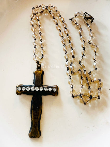 Necklace with a cross pendant and beaded chain on a white background