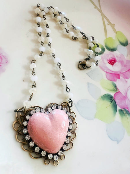 Necklace with a pink heart pendant on a floral background