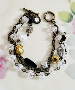 Bracelet with crystal beads and metal chain on a floral background