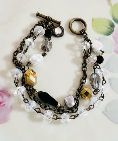 Bracelet with crystal beads and metal chain on a floral background